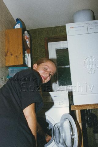 PraktikantInnenhilfe: Einsätze - Praktikantin räumt die Waschmaschine aus; 1999