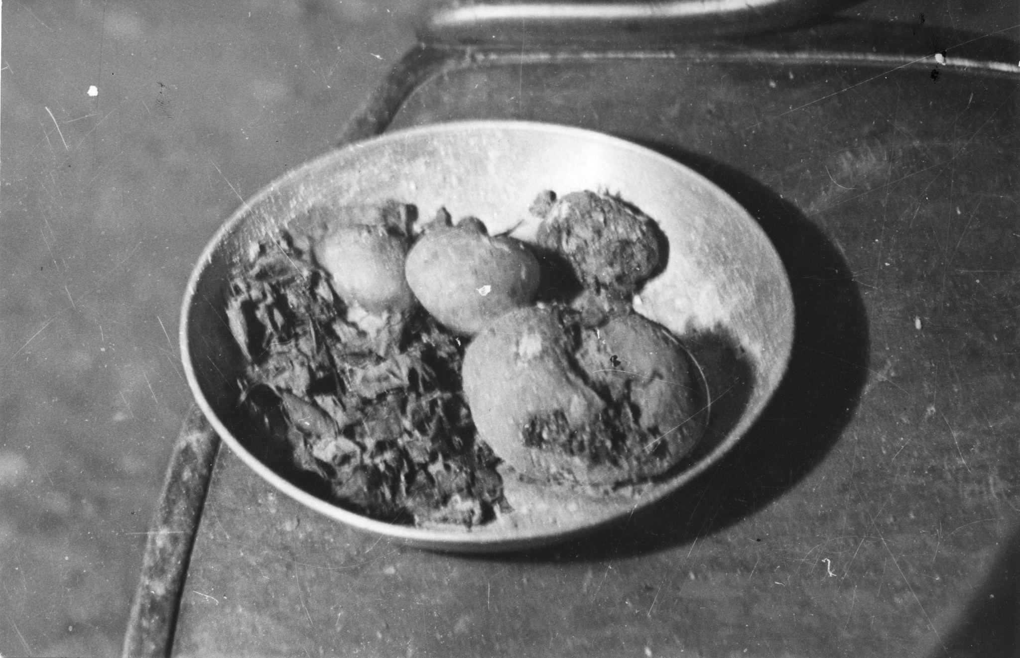 ["Instruments de torture de la Milice et de la Gestapo, 1944"], "Pommes de terre et légumes pourris, tel était le menu des Français de la Résistance, prisonniers des Allemands et de la Milice de Vichy. (Photo provenant de Saint-Etienne)."