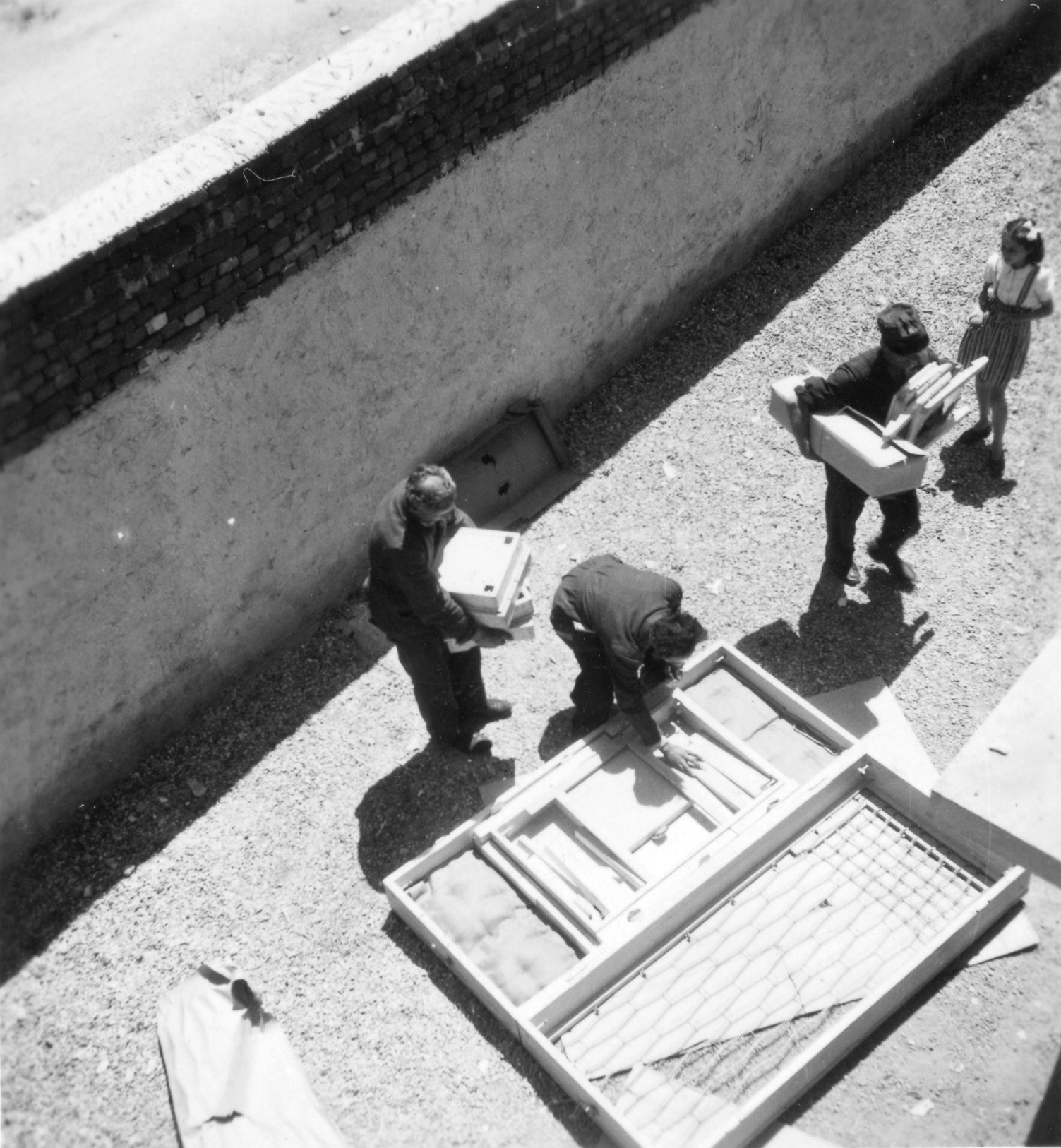 "Milano, Sommer 1946. AERMO-Möbelverteilung und Innenaufnahmen. Die Neubauten sind in aller Eile aufgebaute Mietskasernen (Case Popolari) für Ausgebombte."; Männer packen Better zusammen