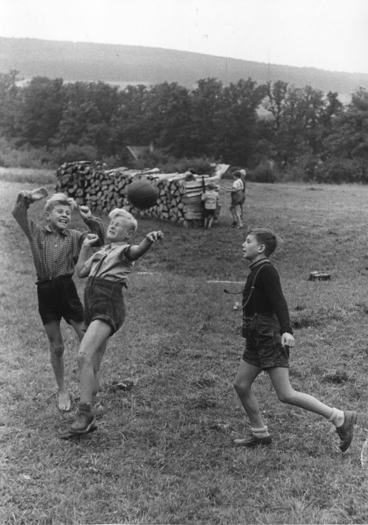 "Sommer 1953 - Hörndlwald: Ferien für Flüchtlingskinder mit Hilfe des Schweizerischen Arbeiterhilfswerkes und der Schweizer Europahilfe. Vokshilfe Wien". Knaben spielen Fussball auf einer Wiese