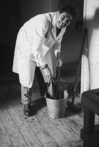Jugendherberge Rotschuo, Gersau - Mann beim Wischen des Fussbodens; um 1955