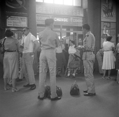Reisende mit Taschen vor dem Geldwechselbüro, Zürich Hauptbahnhof, um 1960