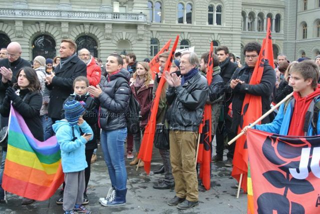 Kundgebung in Bern gegen die Familieninitiative der CVP (16.11.2013, Bern) – klatschende Demonstrierende, teils mit Flaggen