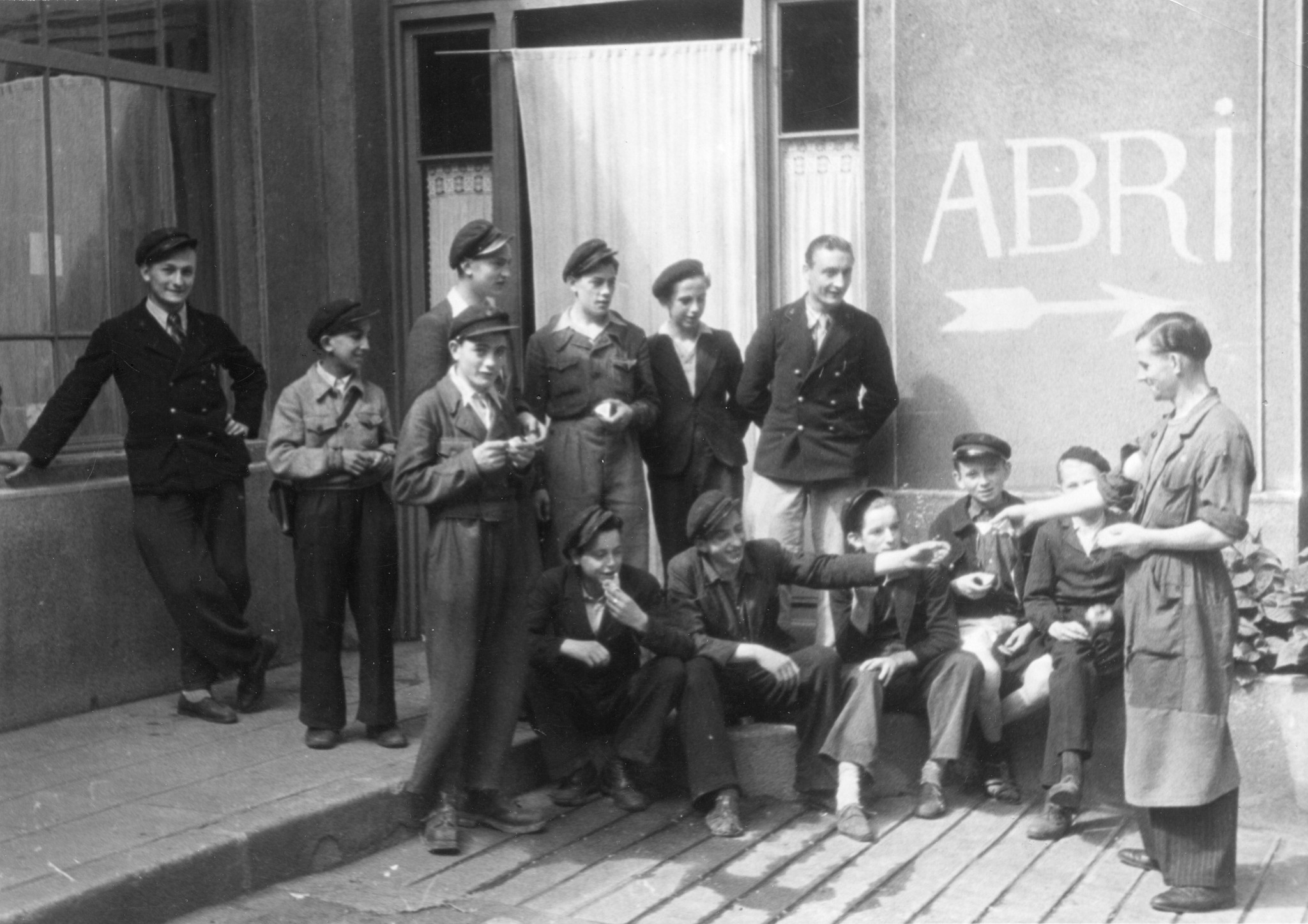 "Saint-Etienne, 1945. Der ältere Kollege verteilt den Telegramm-Austräger die tägliche Ration Käse des Don Suisse. Immer am Montag holt er in unserem Lager die Wochenration ab. Die jungen Pöstler sind schlecht ausgerüstet. [...] Paar Schuhe erha