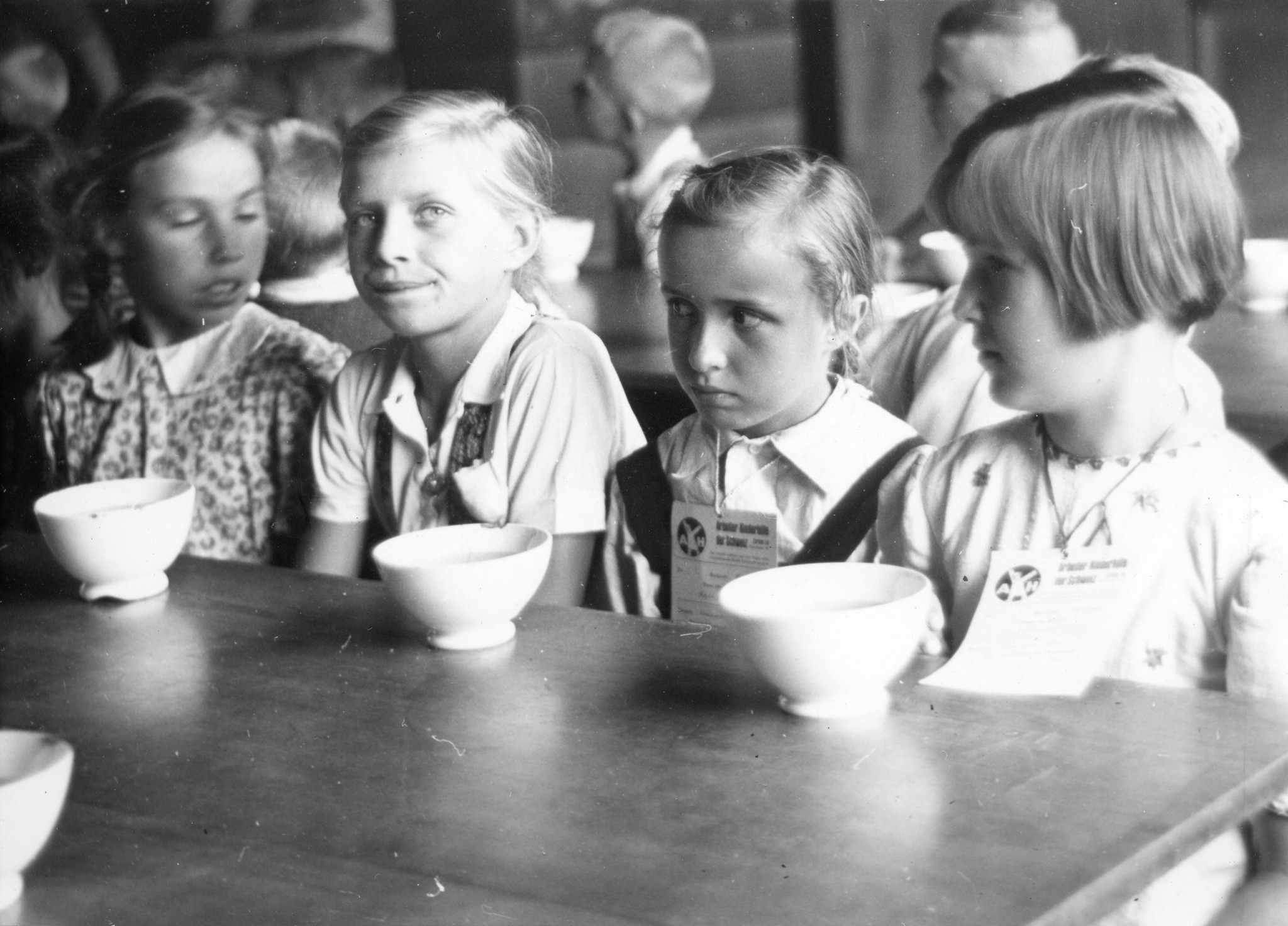 Vier Mädchen sitzen an einem Tisch, vor ihnen stehen Schälchen