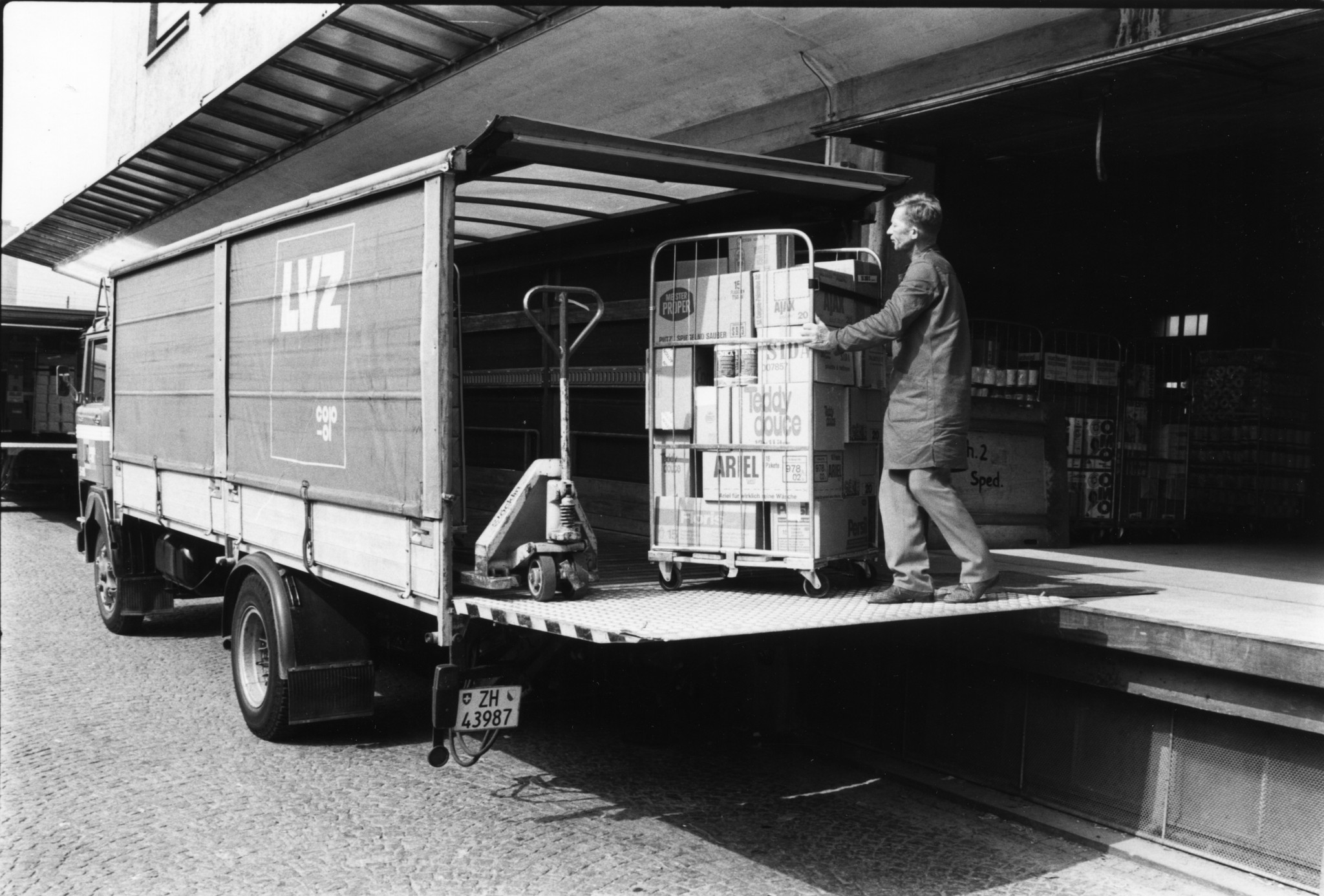 Mann beim Verladen von Waschmitteln in einen Lieferwagen des Lebensmittelvereins Zürich