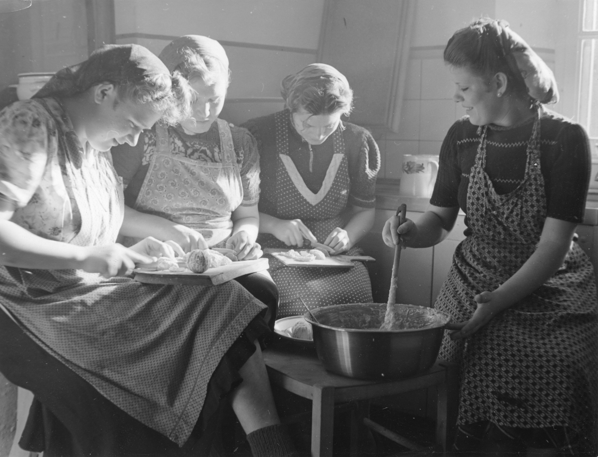 Vier Mädchen sitzen in der Küche und kochen