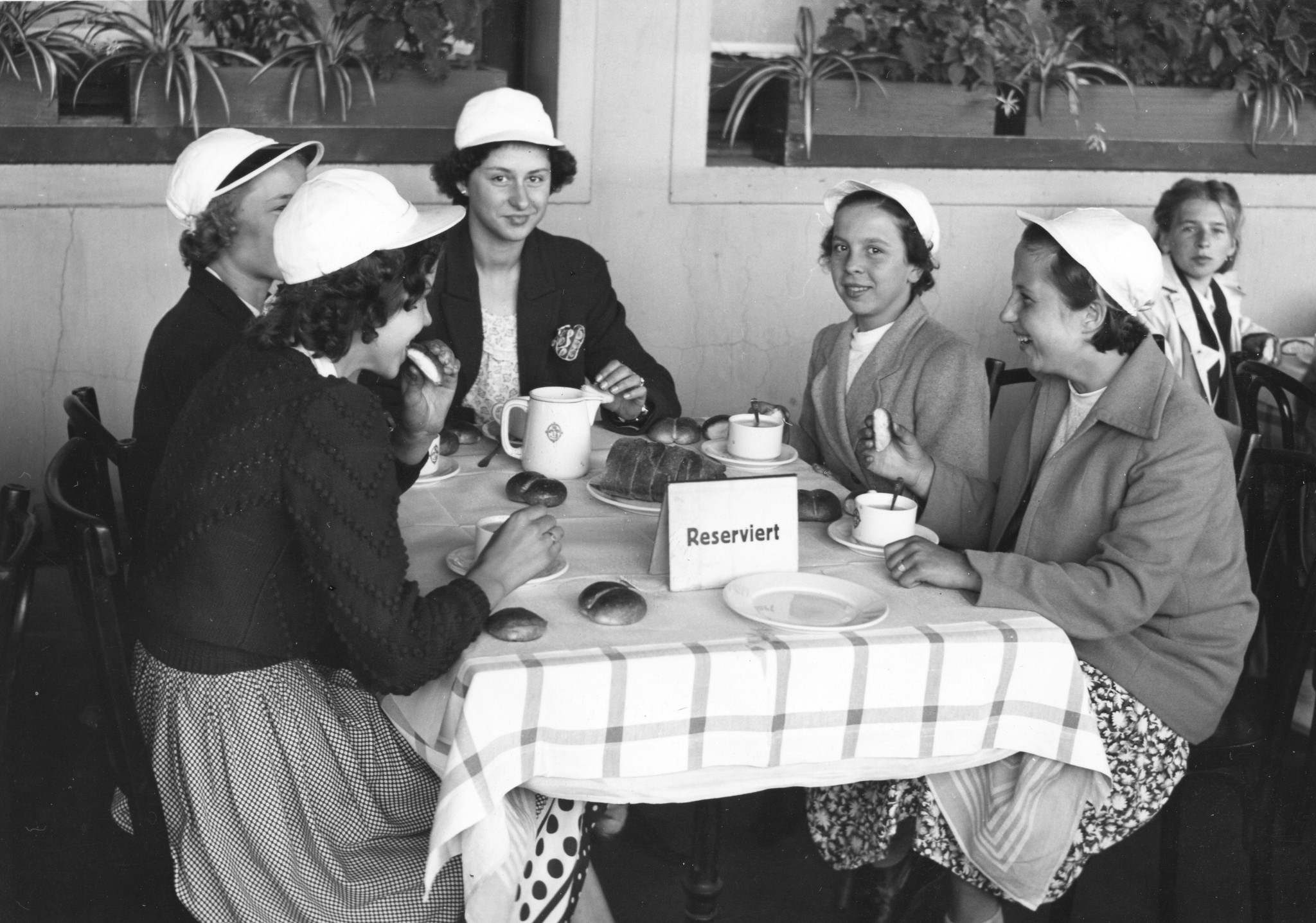 "Belgierkolonie Sommer 1950, Ankunft in Basel"; Mädchen essen Semmel und trinken Ovomaltine