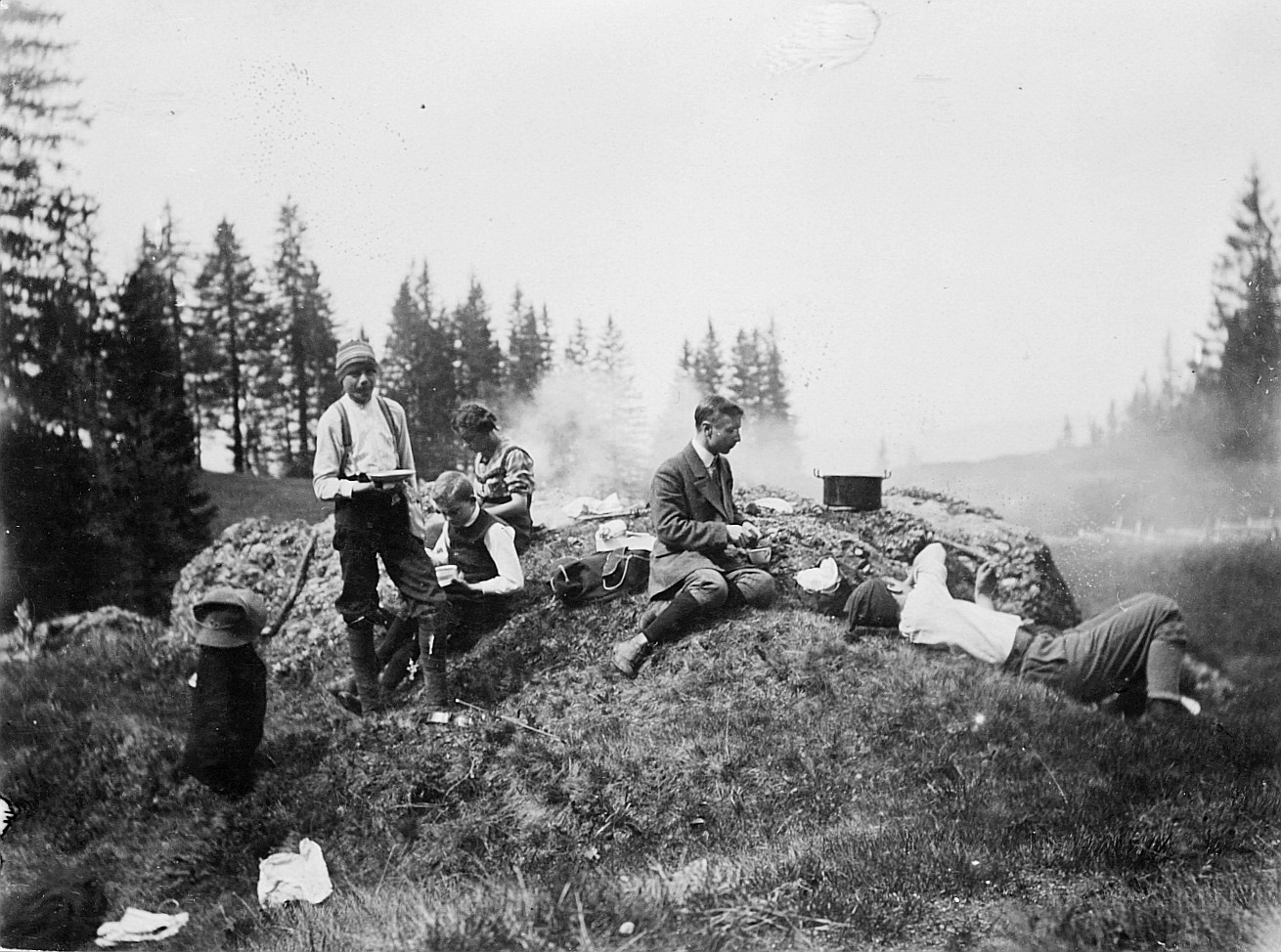 Wandervögel sitzen auf der Wiese und essen aus ihren Essnäpfen (1926)