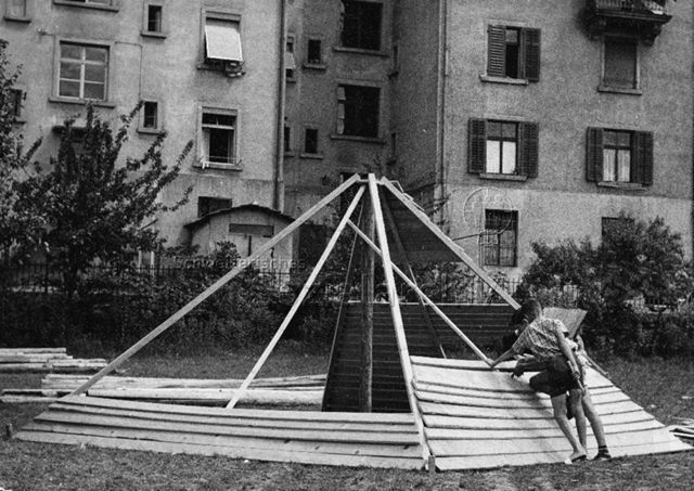 "Robinsonspielplatz Wipkingen", Zürich - Zwei Jungen bauen eine pyramidenförmige Hütte; um 1965