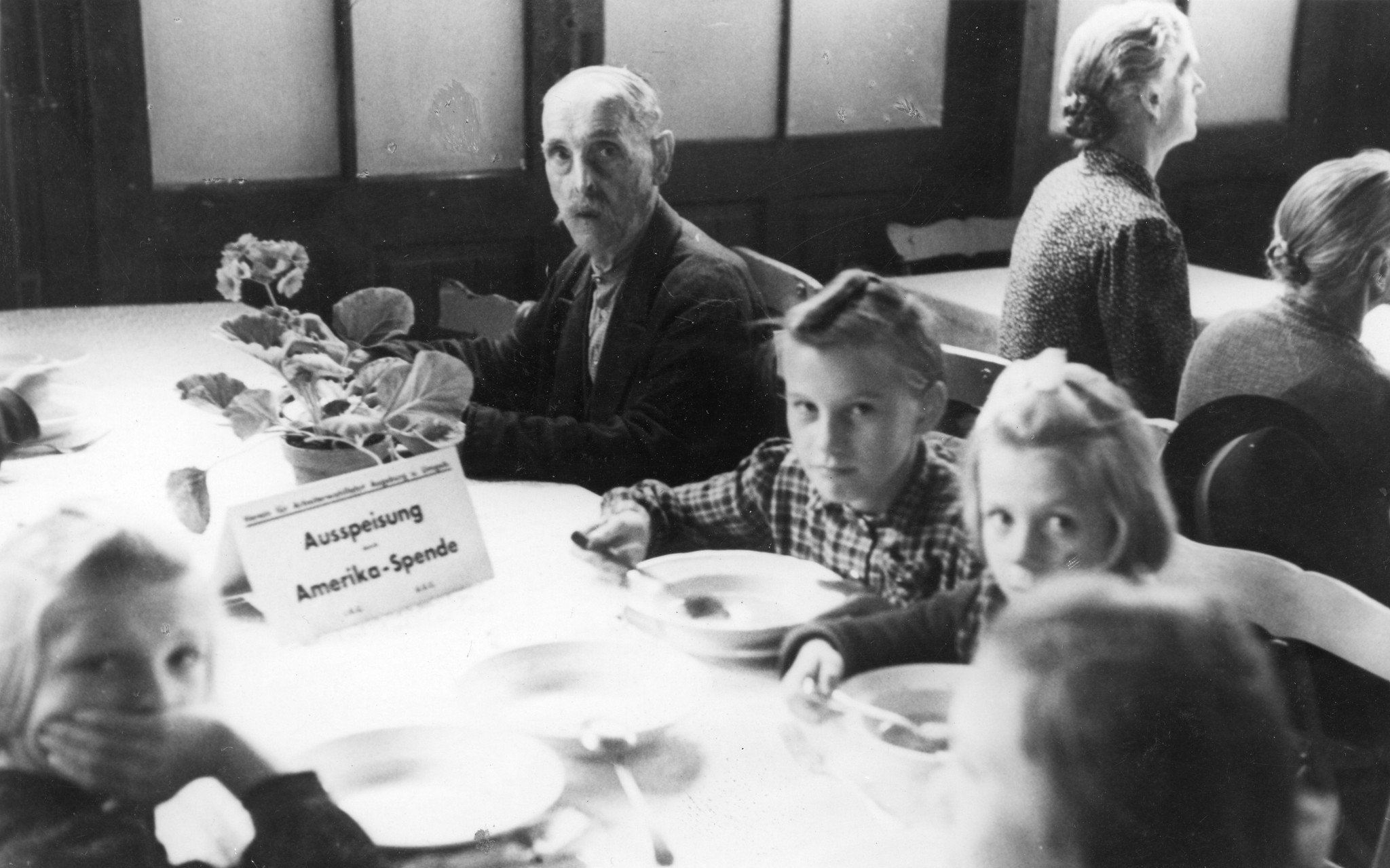 "Ausspeisung in Augsburg/Bayern - Spenden des IRRC (International Relief and Rescue Committee) und USC"; eine Familie isst Suppe