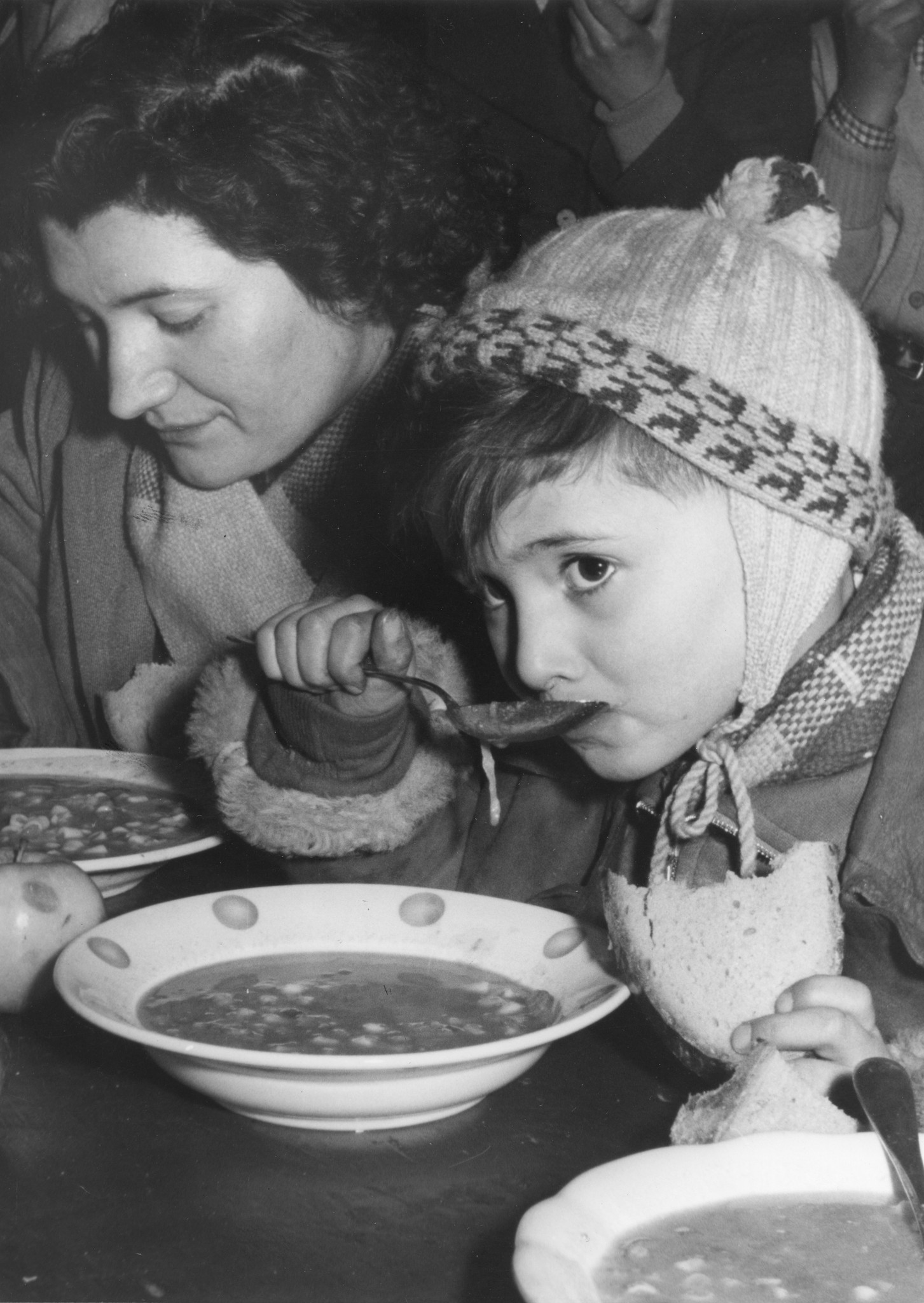 Ein kleiner Knabe und eine Frau essen Suppe
