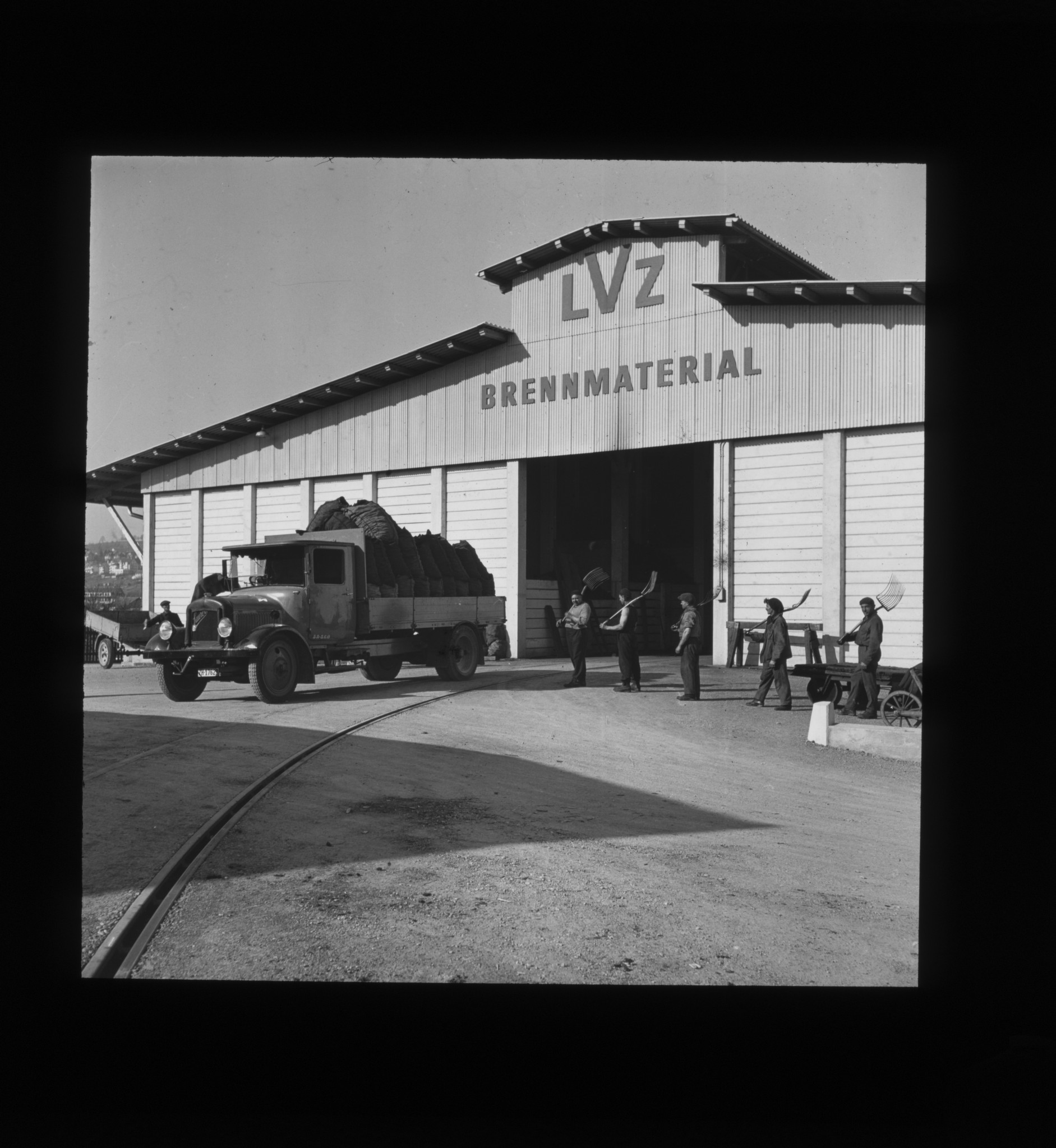 Dia: Brennmateriallager des LVZ an der Turbinenstrasse, davor beladener Lastwagen und Arbeiter.