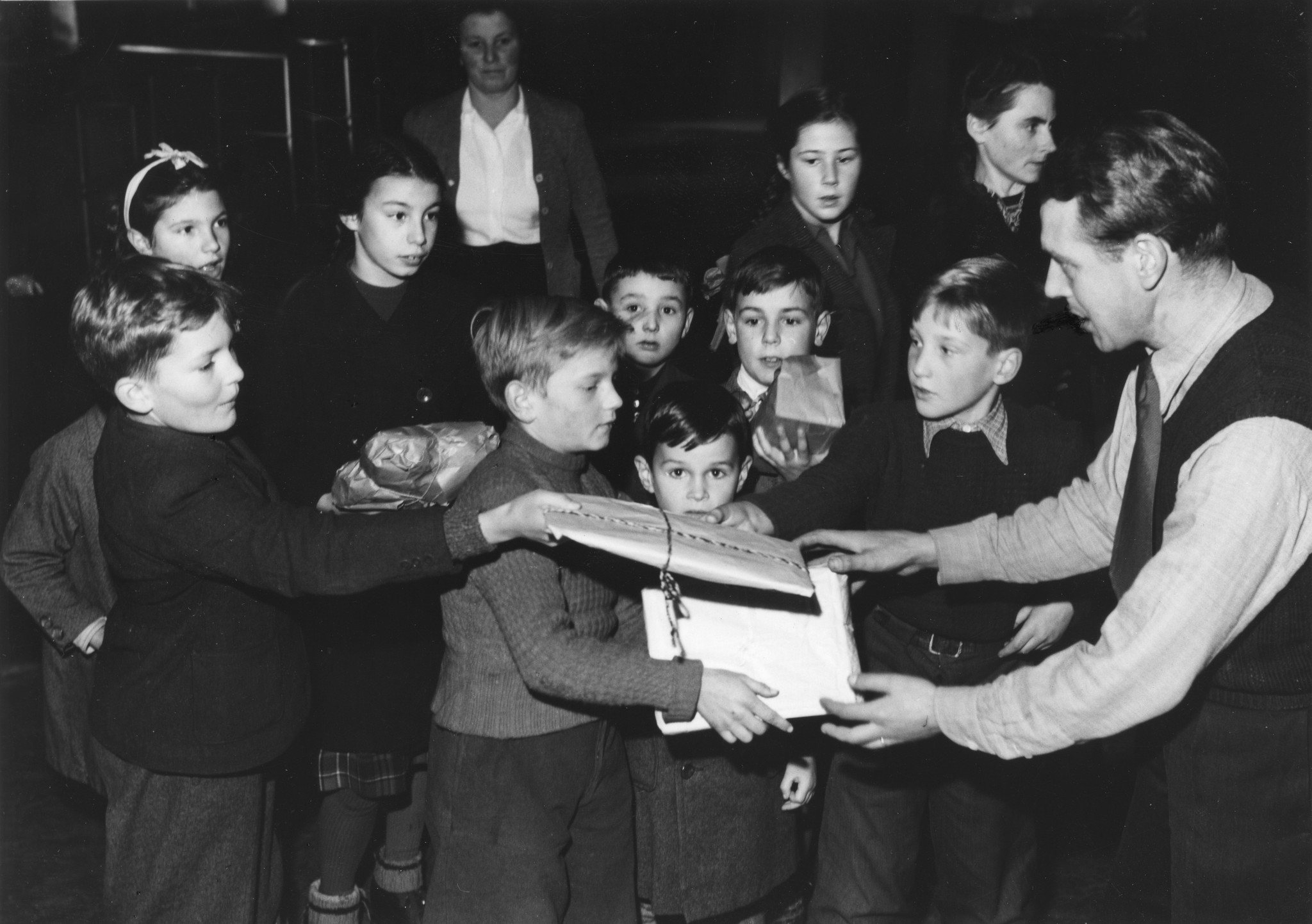 "November 1946, Spielzeugsammlung für unsere Auslandkinderheime, verbunden mit einer Kindervorstellung im Volkshaus Zürich", Kinder mit abzugebenden Spielzeugen und bei der Abgabe ihrer Spielzeugen im Volkshaus