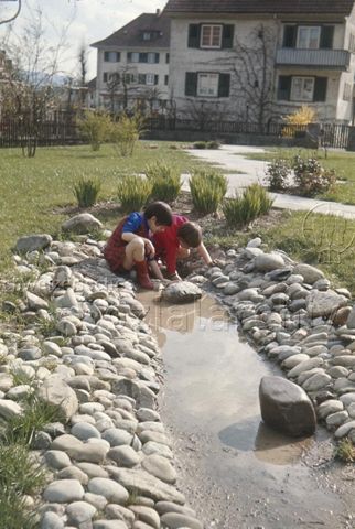 "Siedlungsspielplatz Bundespersonal, Romanshorn" - Kinder beim Spielen im künstlich angelegten Wassergraben; um 1975