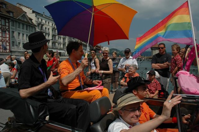 Gesamtschweizerische Lesbian&Gay Pride 2005: "Sowieso" (18.06.2005, Luzern) – Paar mit Regenbogenregenschirm in einem Auto, Kapellbrücke im Hintergrund