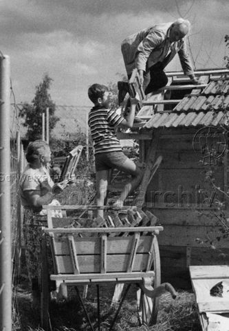 "Freizeitanlage Bachwiesen, Robinsonspielplatz" - Familie beim Dachdecken; um 1975