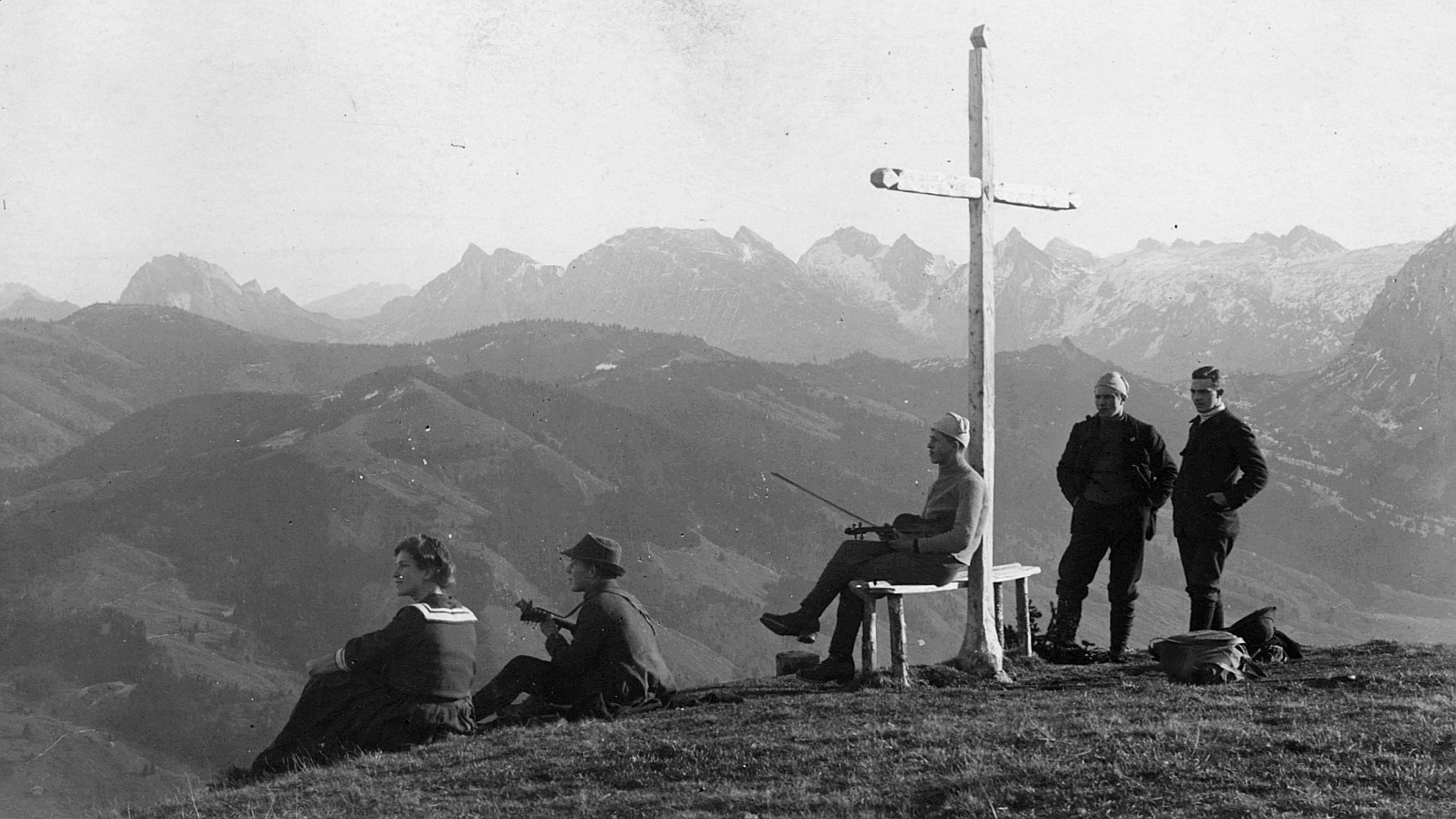 Bergtour: Rast der Wandervögel der Ortsgruppe Winterthur bei einem Holzkreuz - Ein Wandervogel eine Geige tragend (1912)