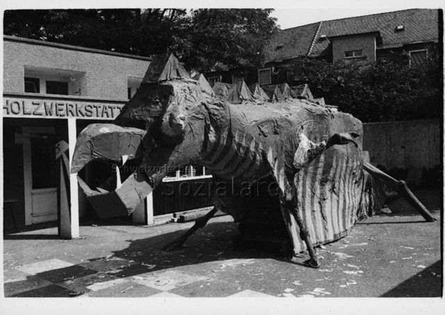 "Buchegg", Zürich - Riesiger gebastelter Drache vor einer Holzwerkstatt; um 1980
