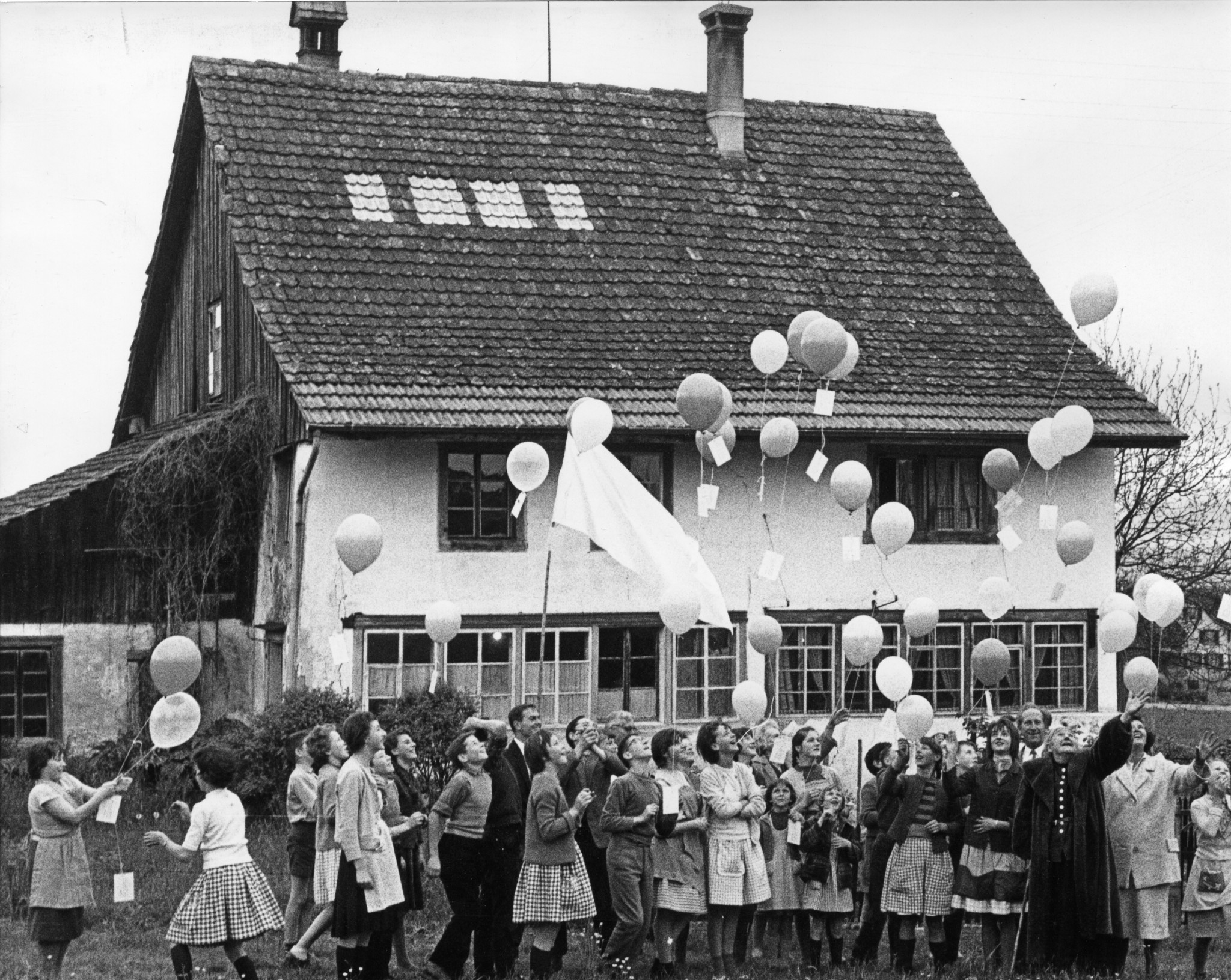 Die Künstlerin Helen Dahm mit Kindern und Luftballonen vor dem Dahmhaus in der Aegertenwies (Oetwil)
