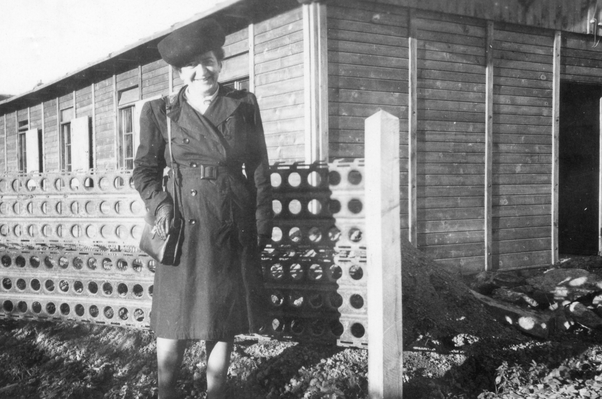 Eine Frau steht vor einem Haus (vermutlich dem gemeinnützigen Zentrum)