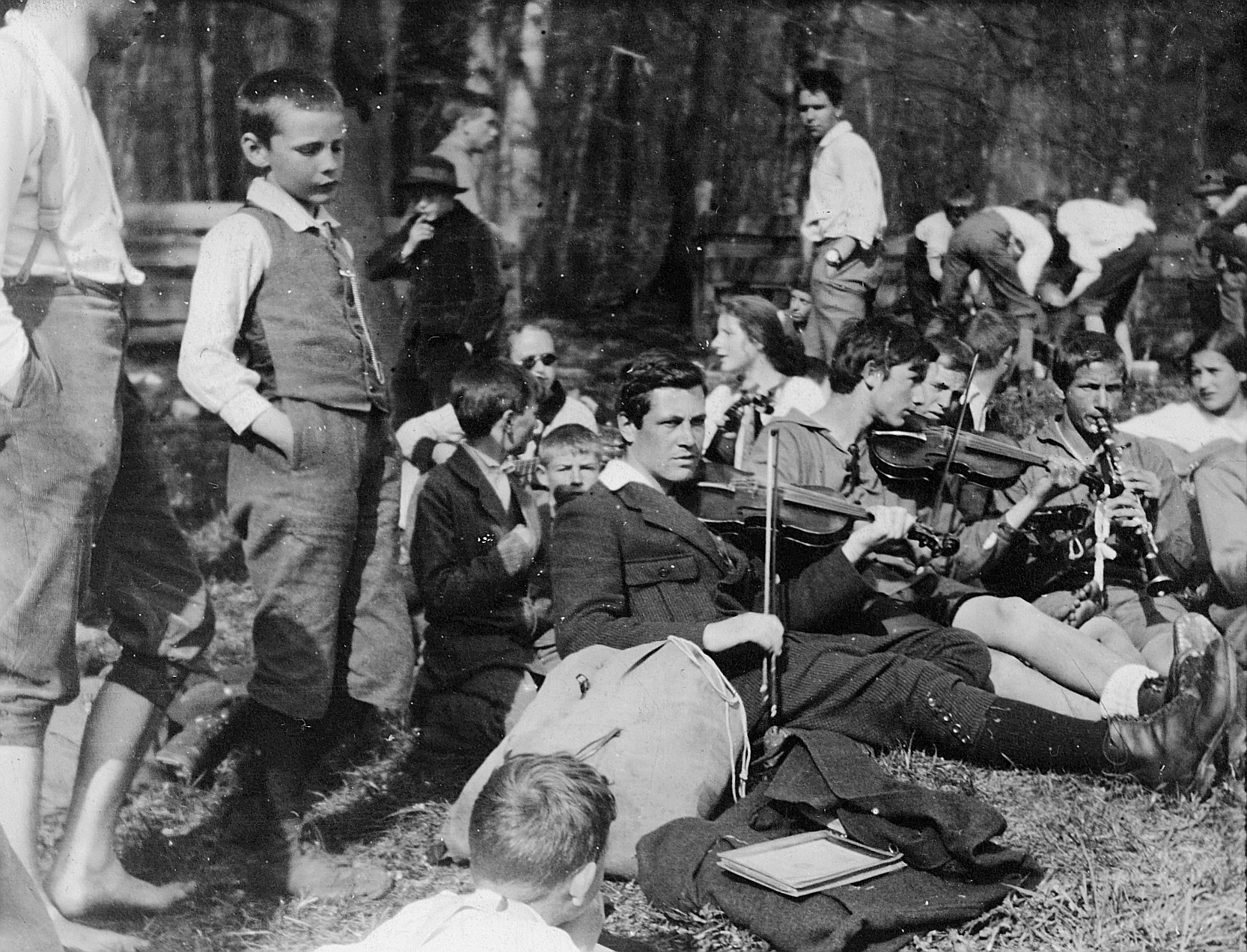 Versammelte Wandervögel (an einer Landsgemeinde?), zwei Wandervögel spielen Geige, ein Wandervogel Klarinette spielend (1920)