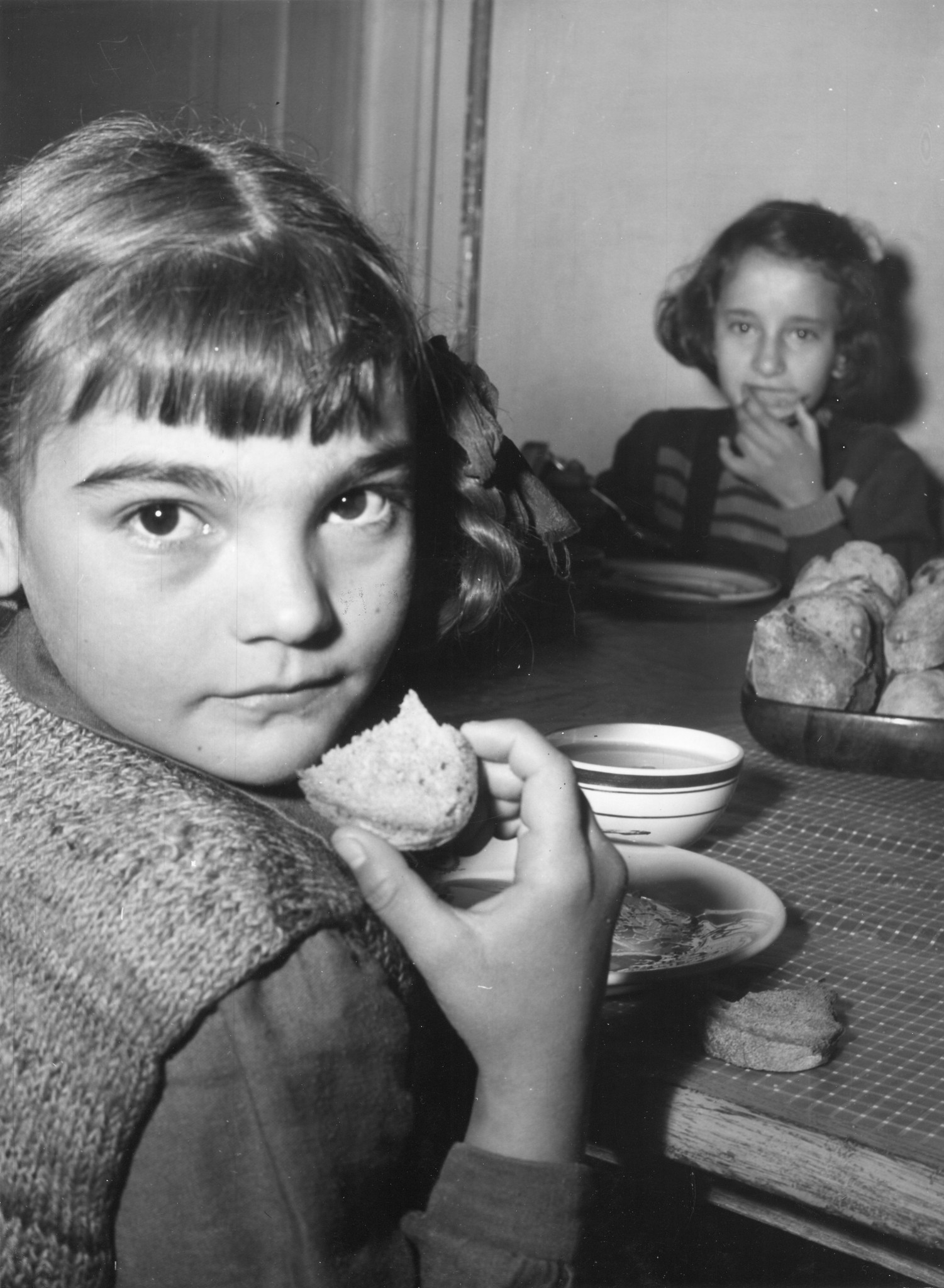 Zwei Mädchen essen Brot zur Suppe