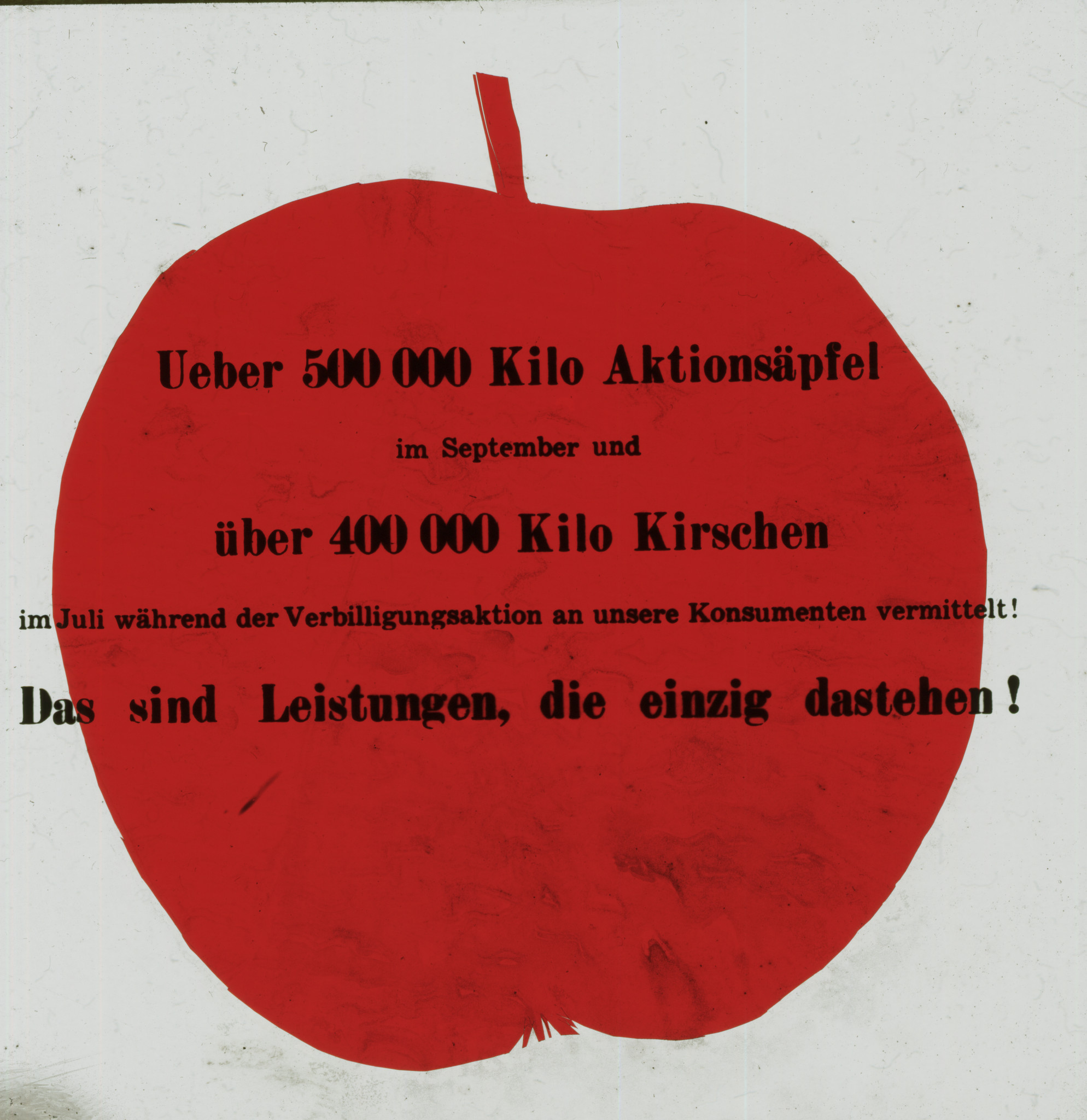 Dia: Apfel, davor Text: "Ueber 500000 Kilo Aktionsäpfel im September und über 400000 Kilo Kirschen im Juli während der Verbilligungsaktion an unsere Konsumenten vermittelt! Das sind Leistungen, die einzig dastehen!".