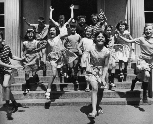 "Freizeitbeschäftigung aussen" - Kinder rennen jubelnd über eine Treppe nach draussen; um 1970
