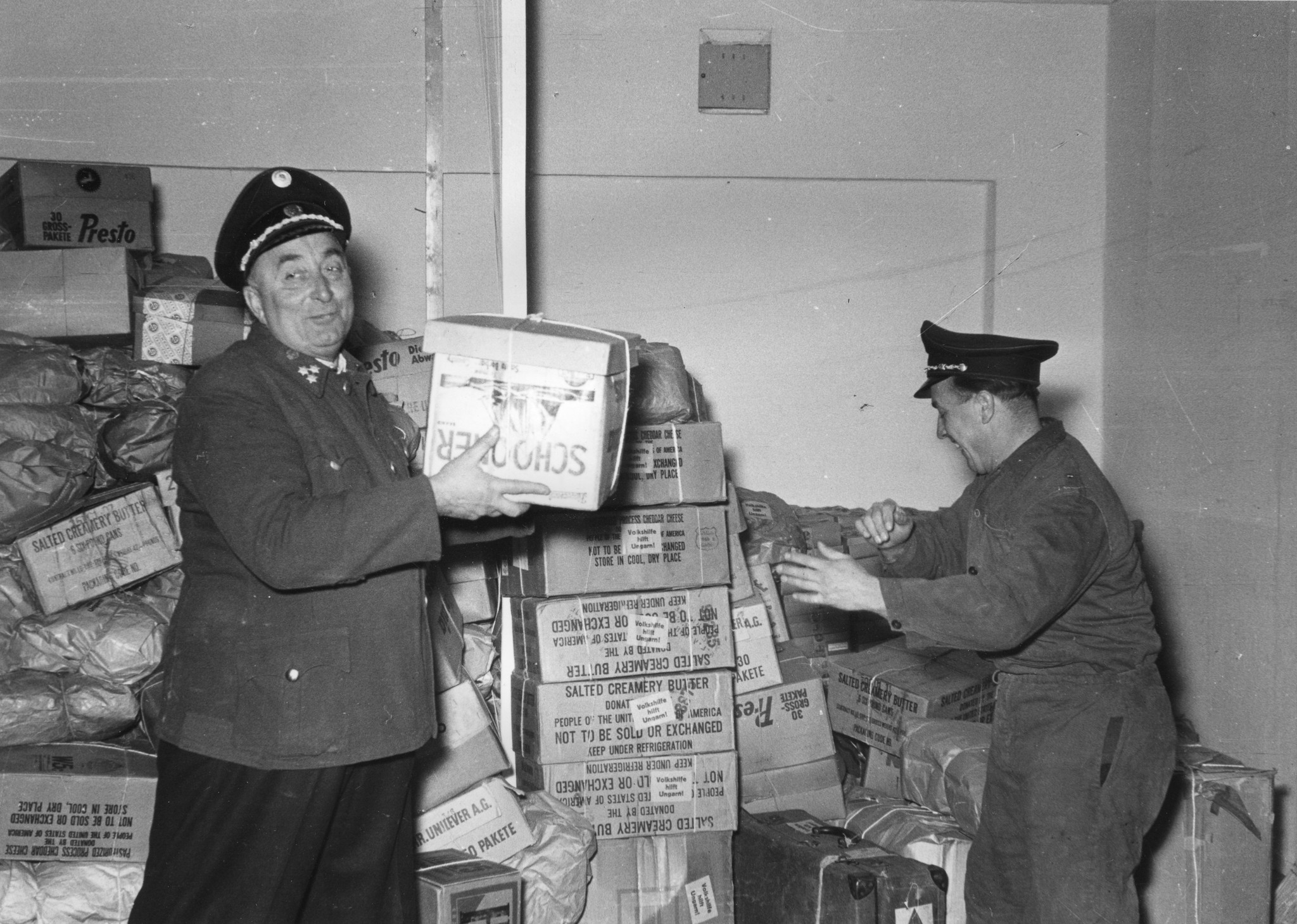 Zwei Männer in Uniform verlagern Pakete aus einem Raum