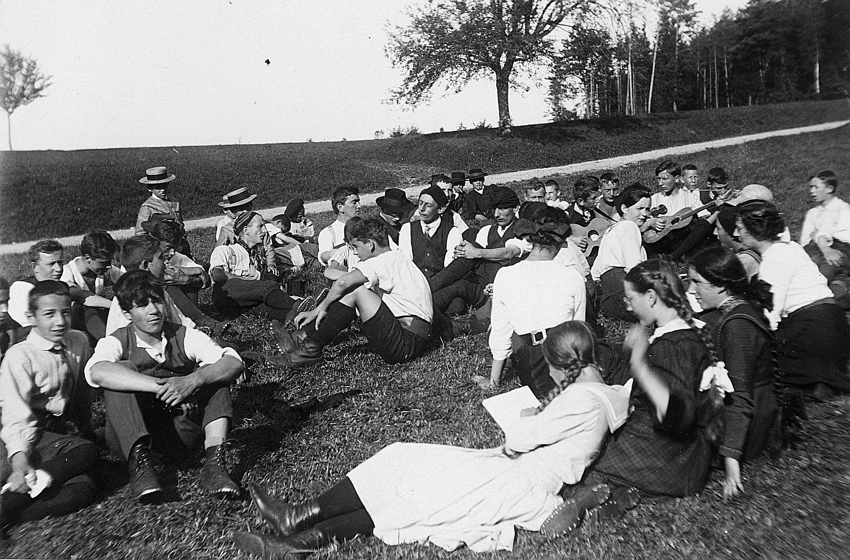Wandervögel sitzen auf der Wiese, zwei Wandervögel spielen Gitarre (1912)