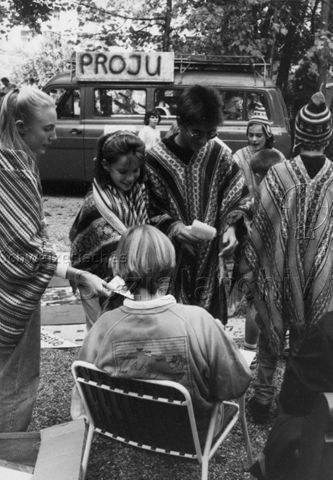 "Spielaktion Versoix 1990" - Kinder verkleidet mit Ponchos, im Hintergrund ein Auto