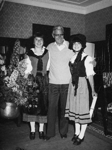 Mann posiert mit zwei Mädchen in Trachten; 1978