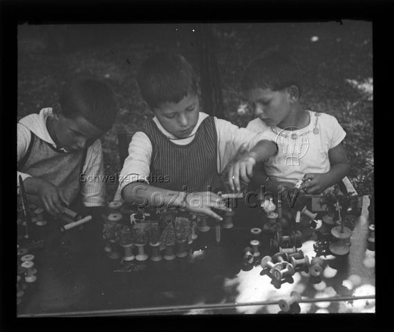 Diaserie zum Thema Kindergarten / Schulkind; Kinder beim Basteln mit Nähfadenspulen, Holzfiguren und Naturmaterialien; um 1930