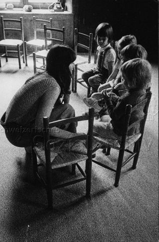 "Club Junger Eltern, Embrach" - Mutter und vier Kinder auf Stühlen; um 1970