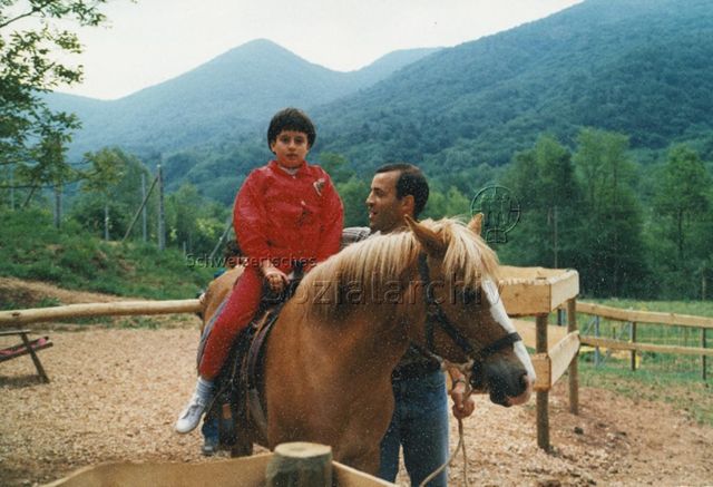 "Bosco della Bella" - Kind sitzt auf einem Pferd, daneben steht ein Mann; 1997