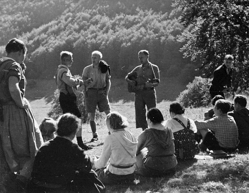 Morgenfeier - Versammelte Wandervögel auf der Wiese: Zwei Wandervögel spielen Gitarre (1937)