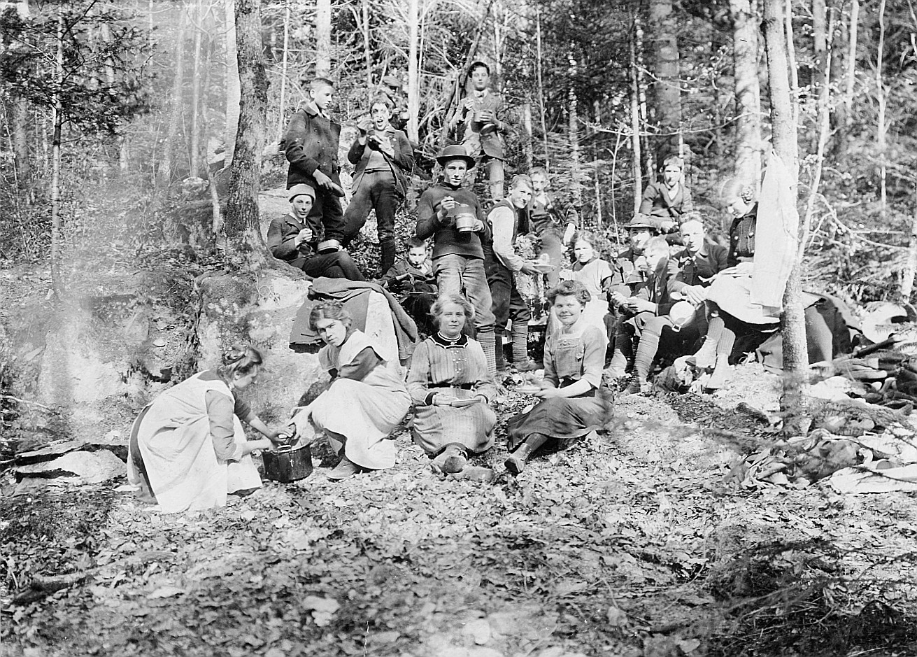Gruppenporträt der Wandervogel-Ortsgruppe Zürich-Altstadt während einer Mahlzeit im Wald (1912)
