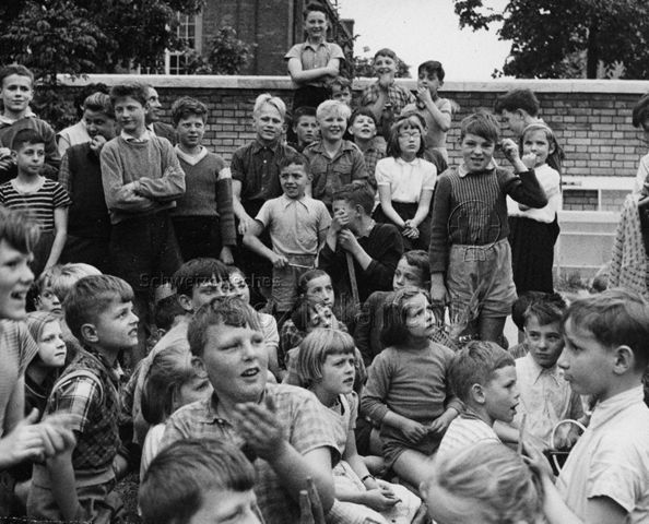Kinder wohnen einer Veranstaltung bei, wahrscheinlich einem Kinder-Zirkus; um 1965