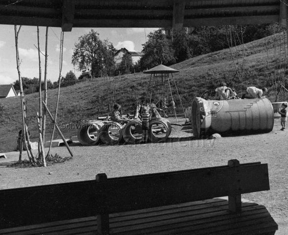 "Kinderspielplatz Sonnengarten, Zürich" - Kinder beim Spielen auf Betonröhren, Klettergerüst; um 1960