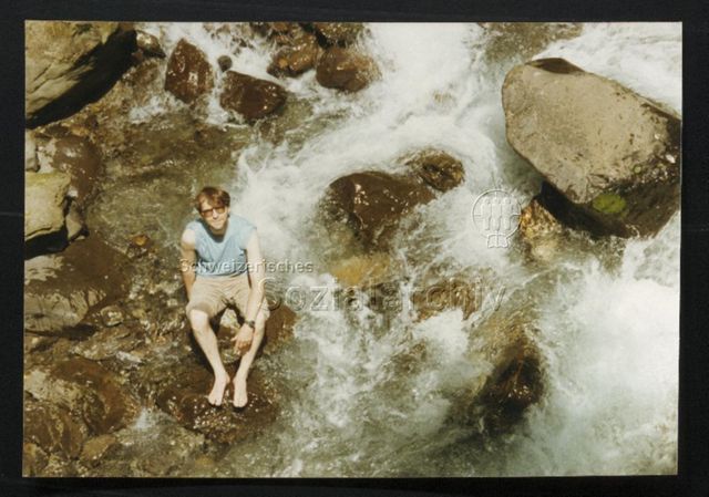Person auf Stein im Fluss