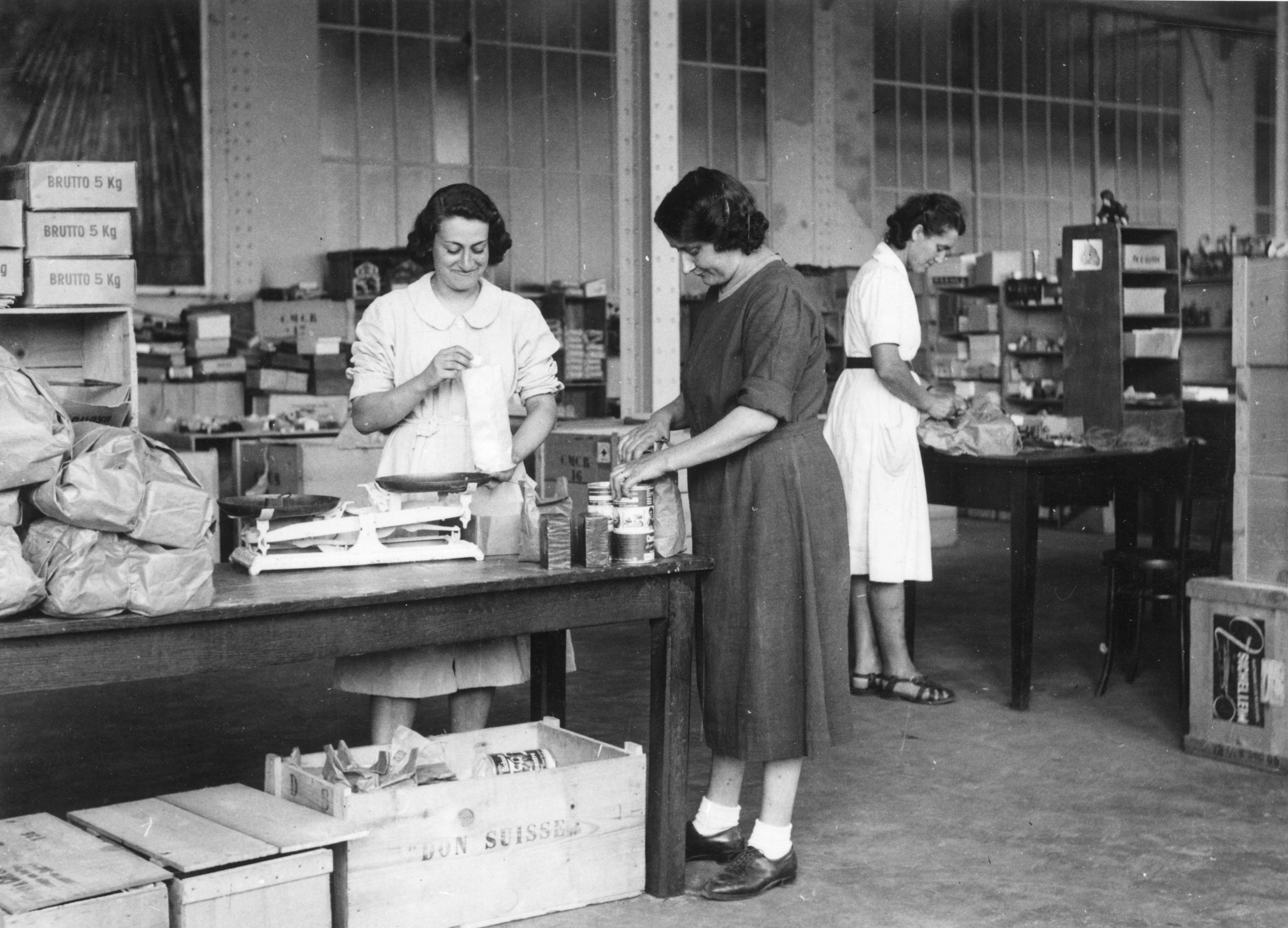 "Lyon 1945. Unsere Helferinnen bei der Arbeit." Frauen beim Vorbereiten von SAH-Lebensmitteln, Kisten "Don Suisse"