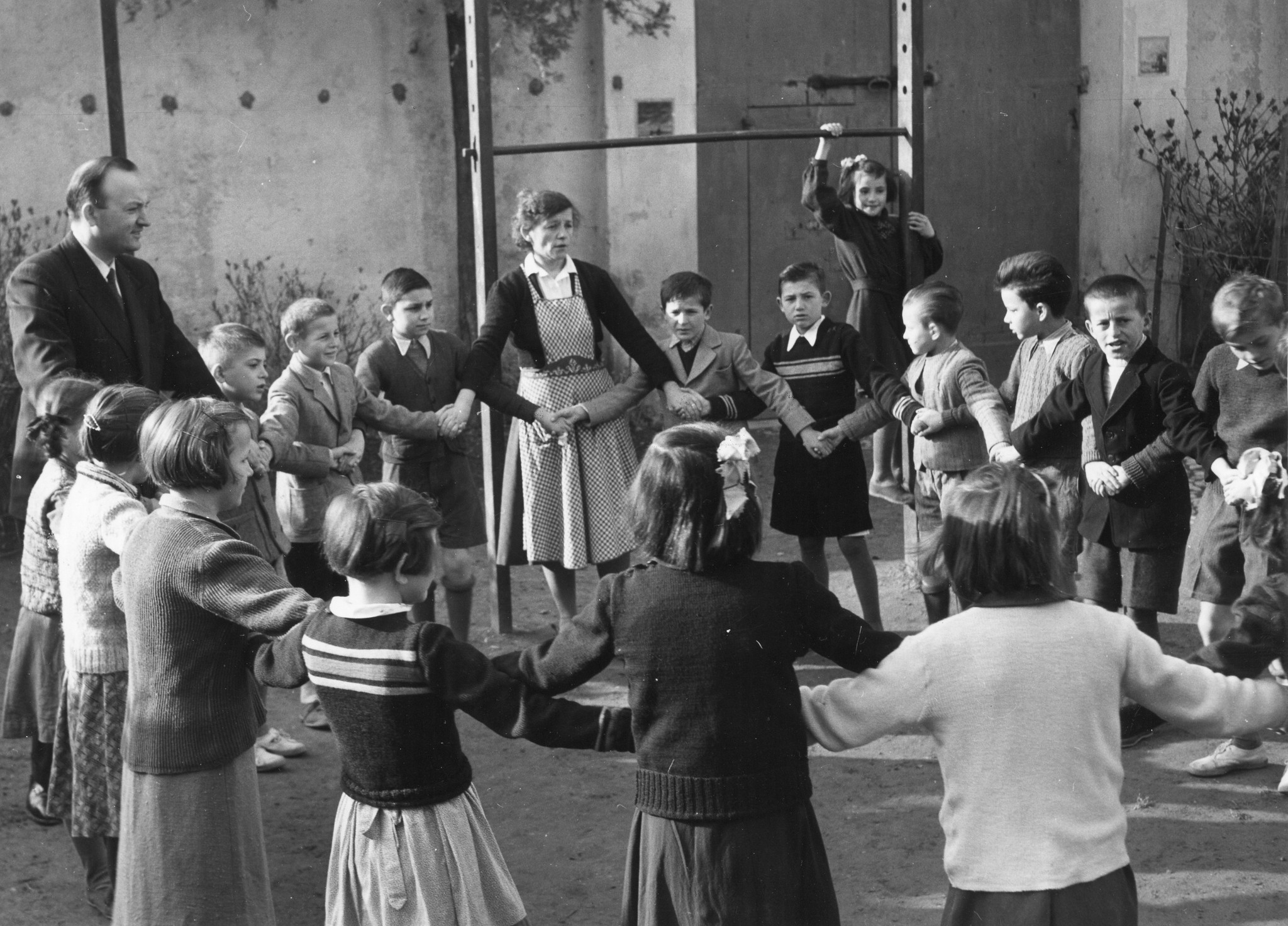 Betreuer tanzen mit den Kindern einen traditionellen jugoslawischen Tanz