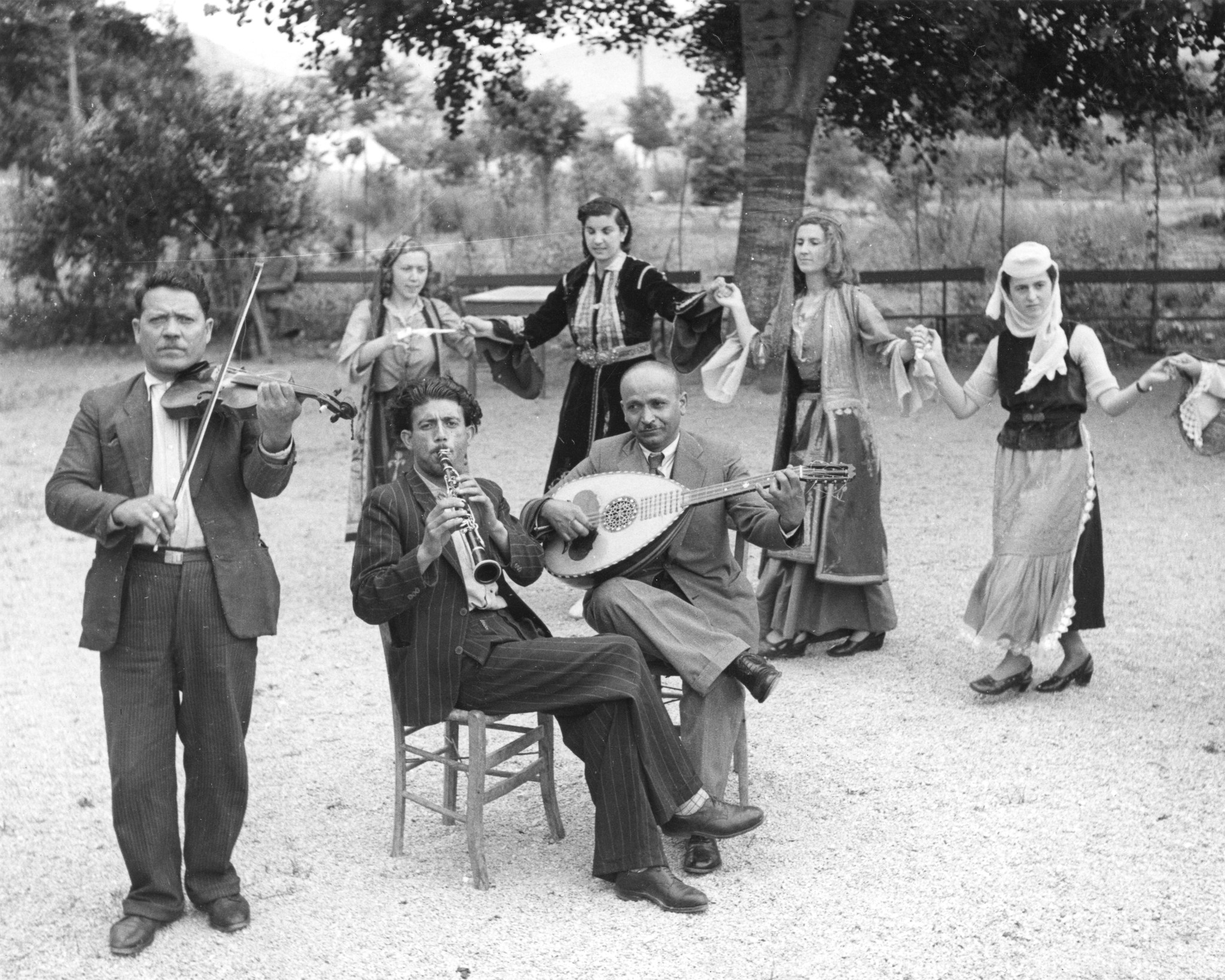 "In a Greek village: musiciens and young girls dancing in Greek national costumes. - Musiciens et villageoises en costumes regionaux,..." - An einem nationalen Feiertag, in einem Dorf, musizieren und tanzen Leute in traditionellen griechischen T