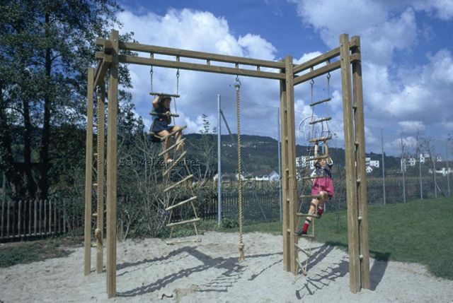 "Kinderspielplatz Riehen" - Zwei Mädchen steigen die Strickleitern hoch; um 1975