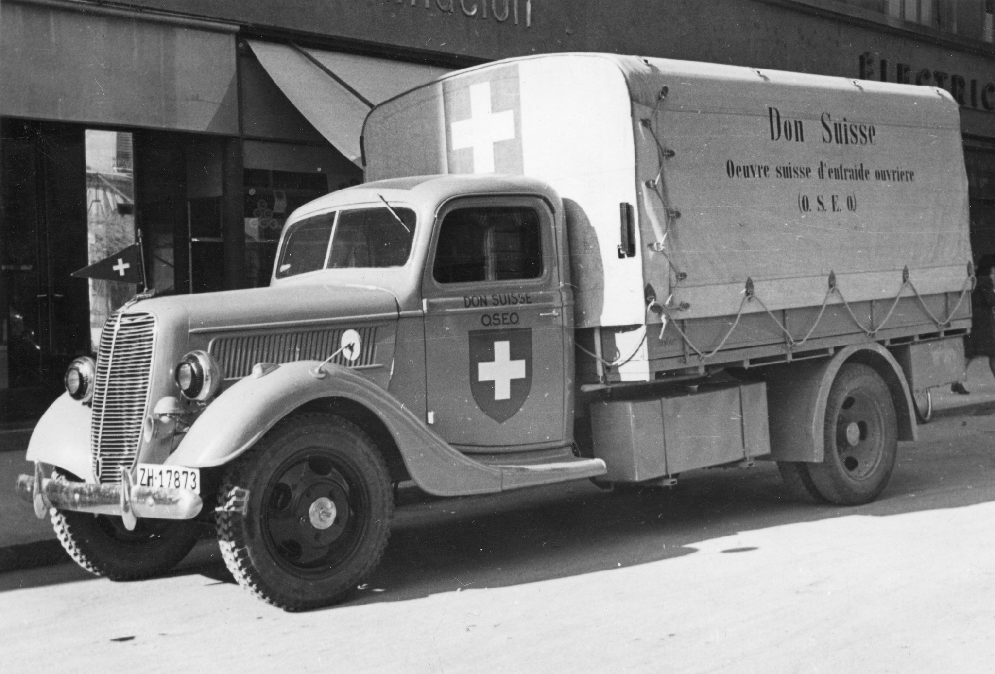 "Der Camion des SAH's trifft in Lyon ein um beim Verteilungsdienst eingesetzt zu werden." Auf dem Lastwagen: "Don Suisse. (O.S.E.O.)" und Schweizer Fahne