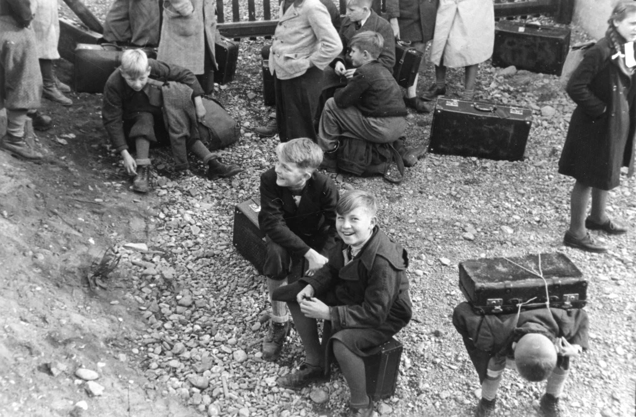 "Hasliberg, Oktober - November 1945. Wiener Arbeiterkinder kommen an."; Kinder sitzen auf ihren Koffern und warten
