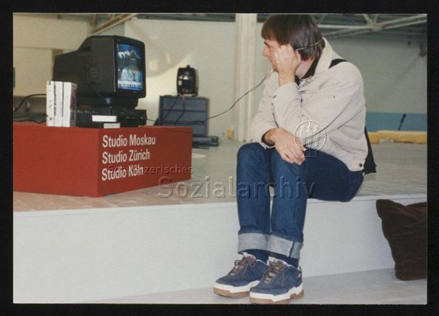 Ausstellungsansicht mit Besucher*in vor Monitor "Studio Moskau, Studio Zürich, Studio Köln"