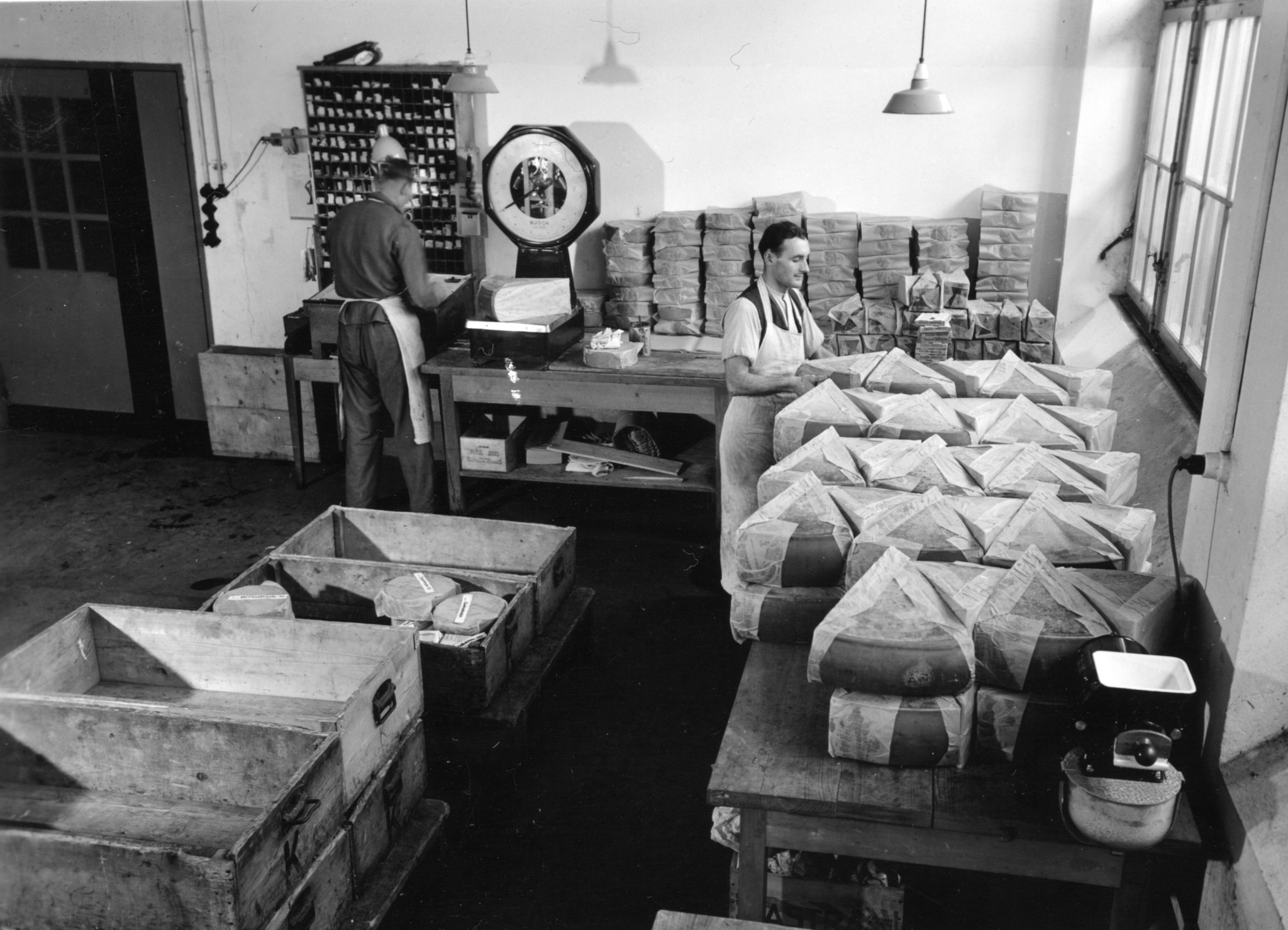 Männer beim Verpacken von Käse in der Käse-Spedition