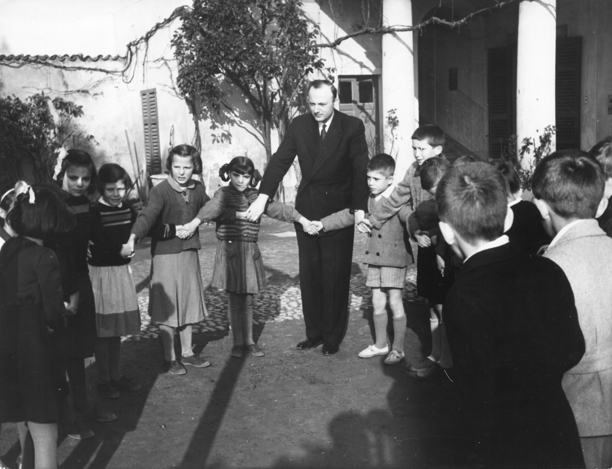 Betreuer tanzen mit den Kindern einen traditionellen jugoslawischen Tanz